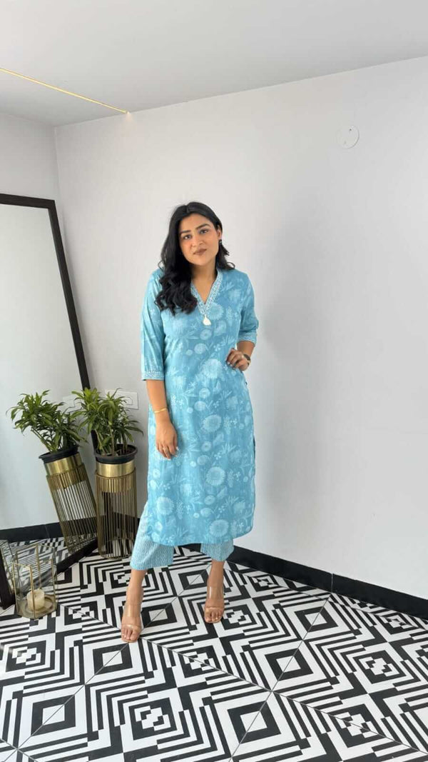 Woman wearing a blue printed kurta standing on black and white geometric floor design