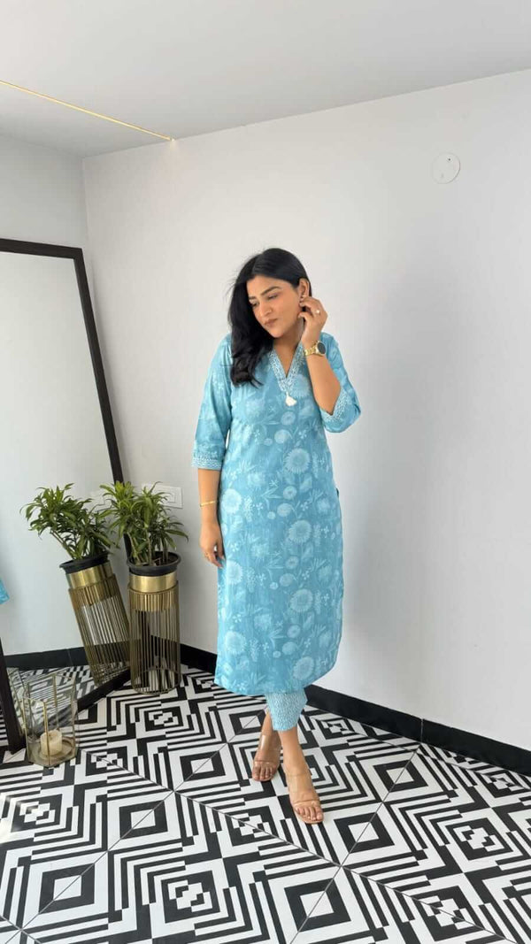Woman wearing blue printed kurta standing on black and white patterned floor indoors