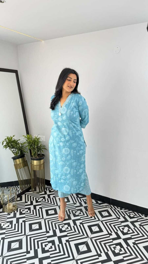 Woman wearing light blue floral kurta standing in a modern room with geometric black and white floor