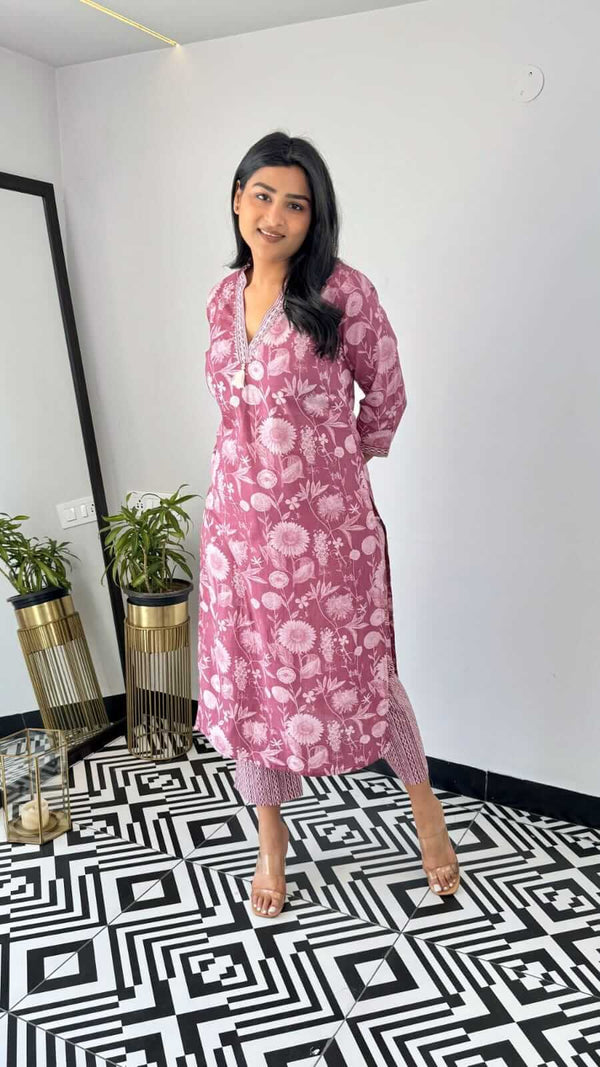 Woman wearing yellow and pink office wear kurta with floral pattern standing in modern room