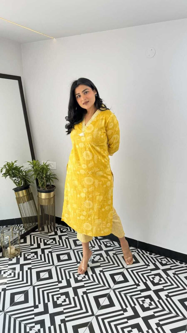 Woman wearing yellow and pink office wear kurta standing on black and white patterned floor indoors