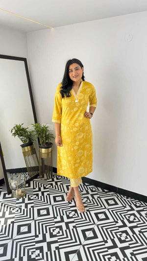 Woman wearing yellow and pink office wear kurta with three-quarter sleeves and floral print standing indoors