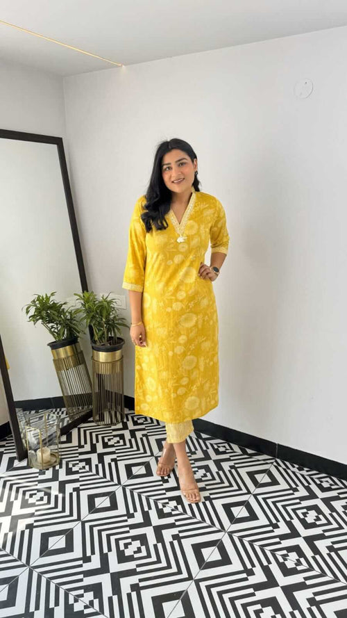 Woman wearing yellow and pink office wear kurta with three-quarter sleeves and floral print standing indoors
