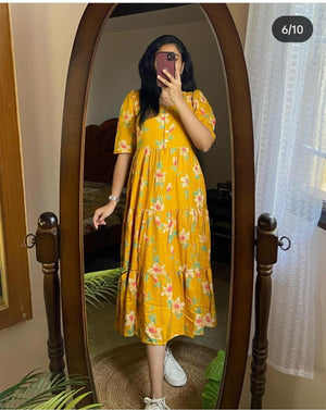 Woman wearing yellow casual kurti with sleeves and floral print taking mirror selfie