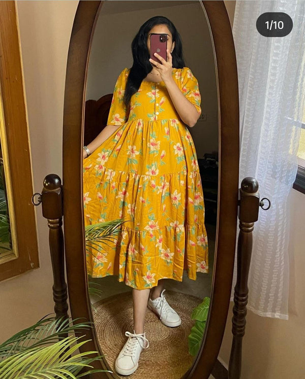 Yellow casual kurti with sleeves floral print worn by woman taking a mirror selfie with white sneakers